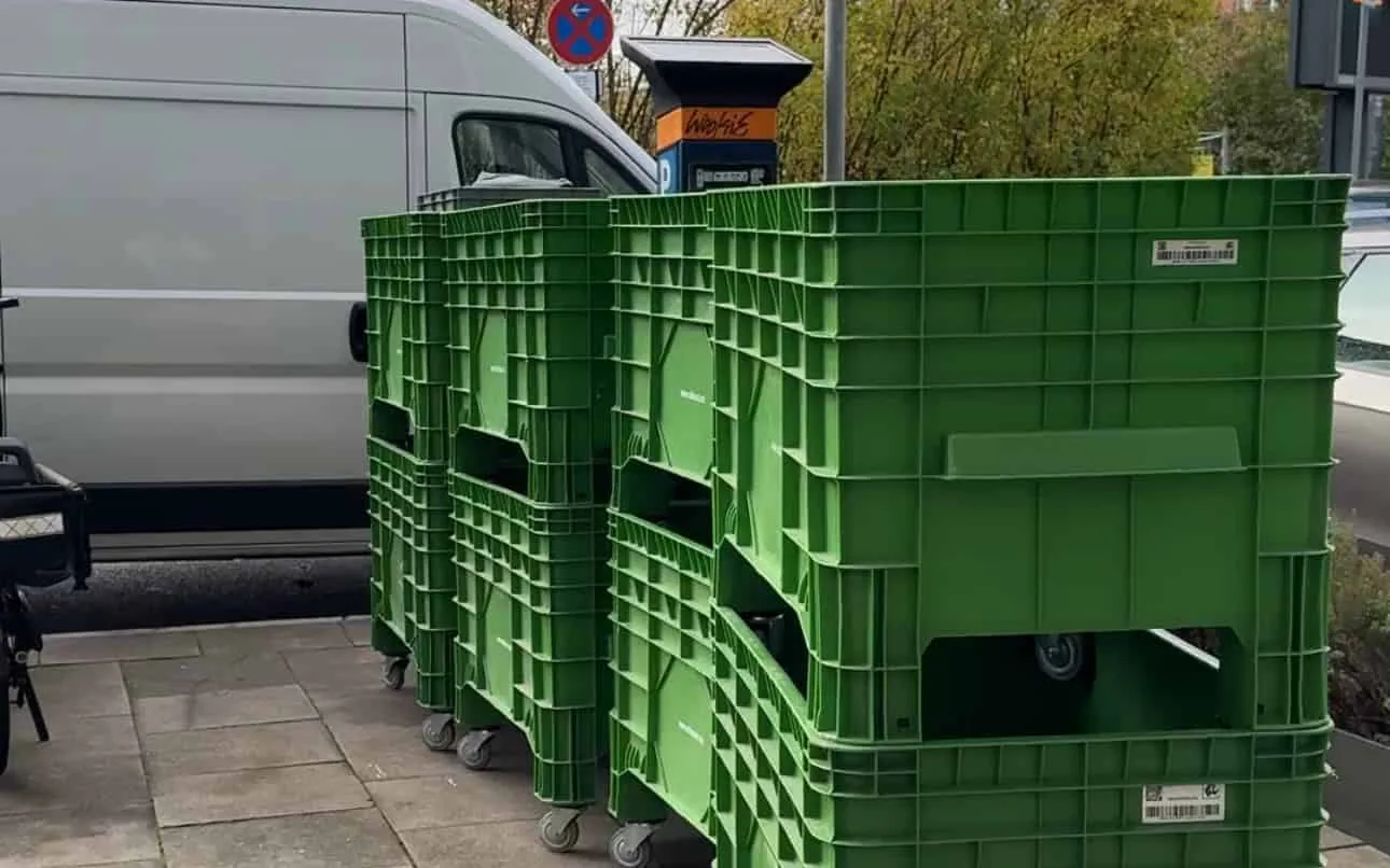 Grüne Mehrweg-Umzugsboxen vor einem Hamburger Wohnhaus